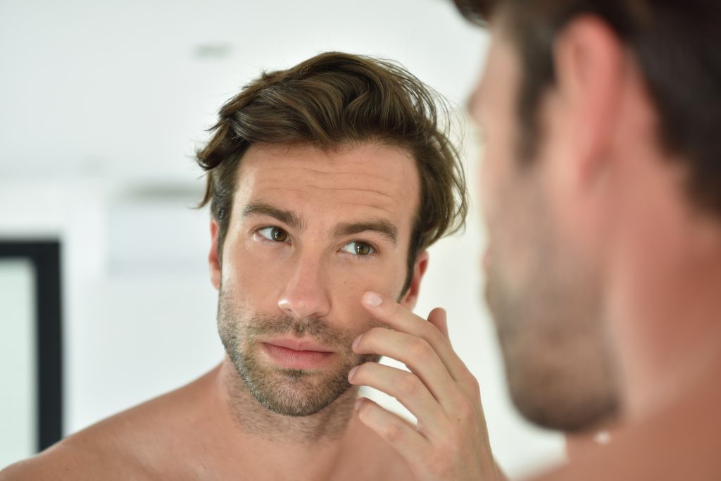 Attractive man looking in the mirror