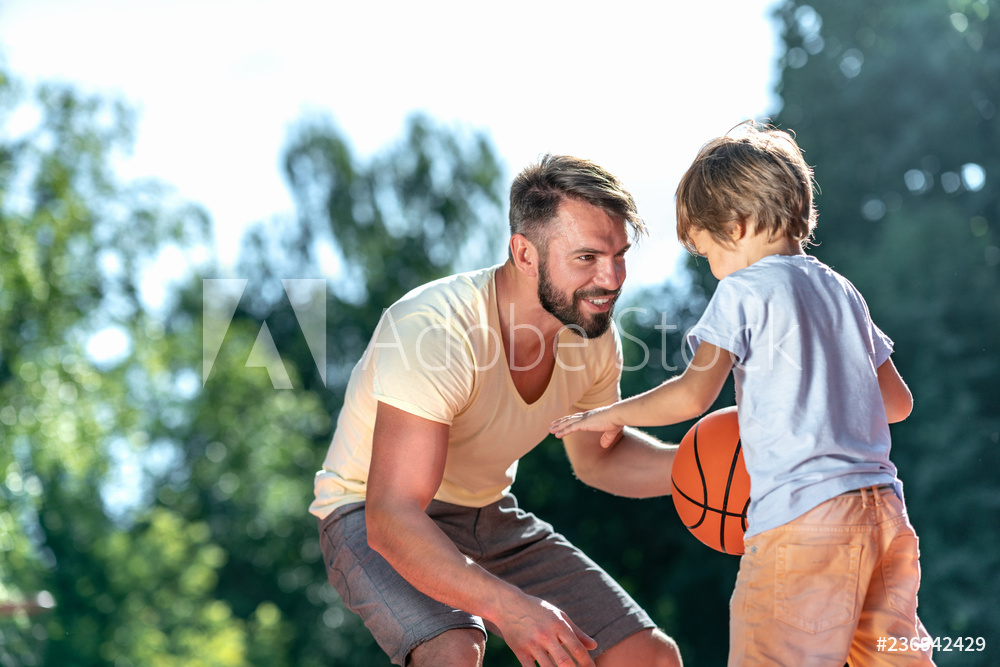 Man and young son playing basketball